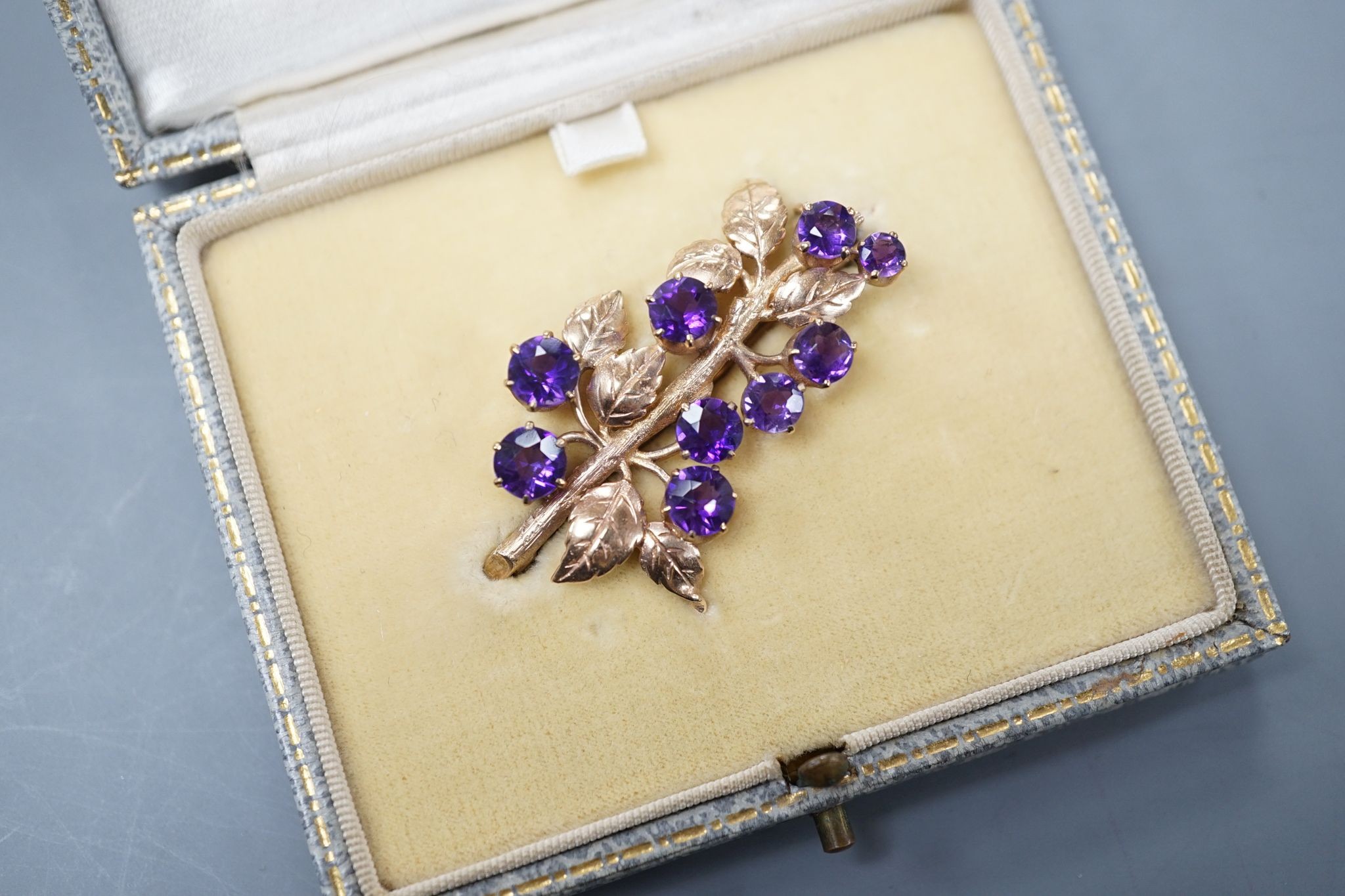 A modern 9ct gold and nine stone amethyst set spray brooch, 42mm, gross 7.6 grams, in fitted box.